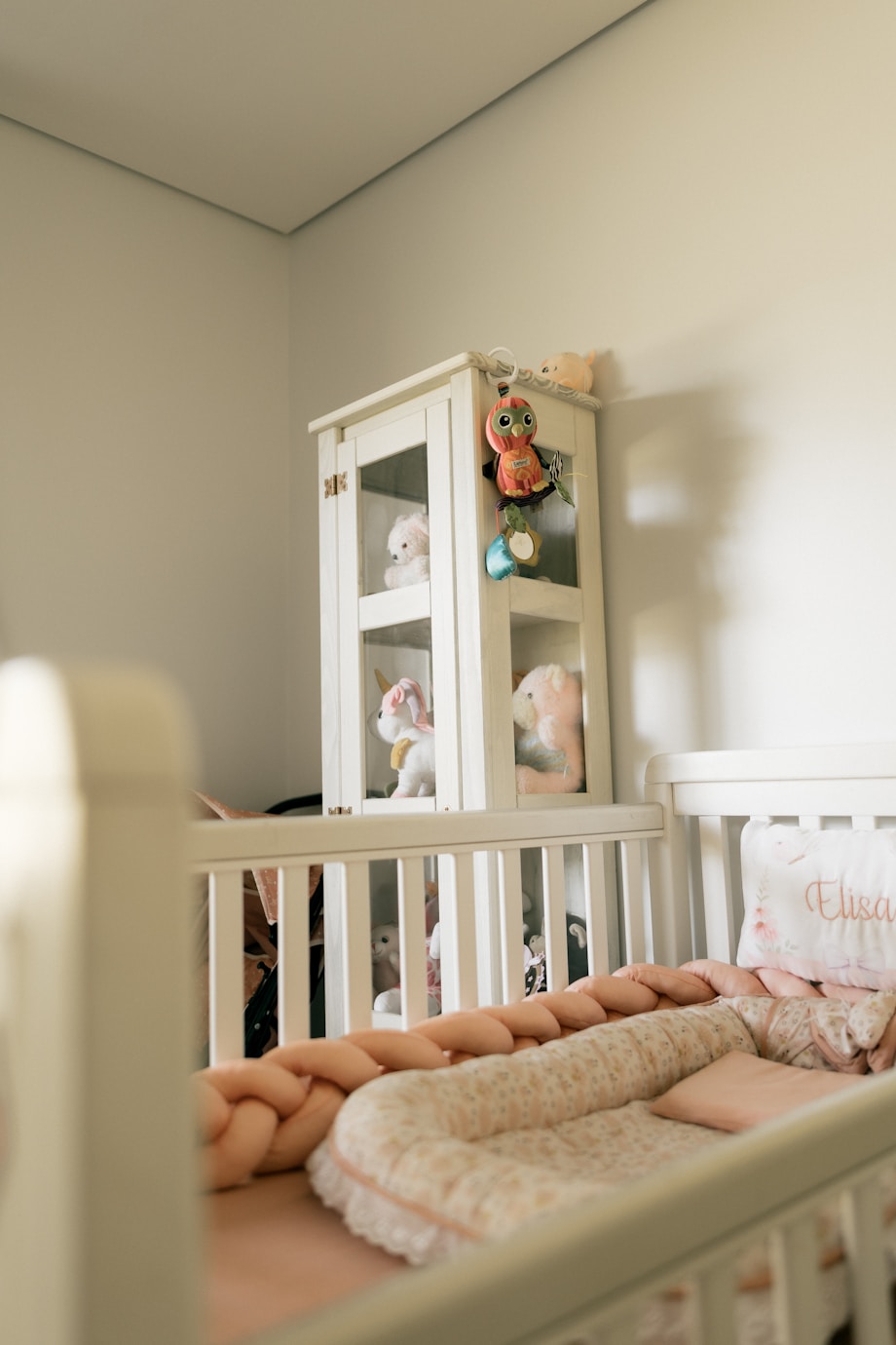 Neutral Australian-style nursery with crib and toy shelf